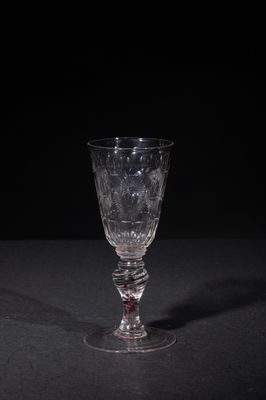 a close up of a wine glass on a table with a black background
