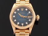 an image of a gold wrist watch with blue dial and diamonds