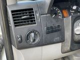 a dashboard of a vehicle with a clock and a steering wheel