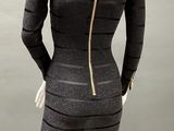 a mannequin wearing a black and gray dress with gold zippers