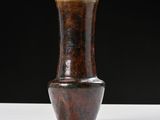 a brown vase that is sitting on a white table