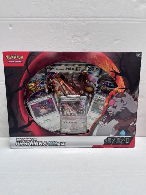 La boîte contient un assortiment de cartes Pokémon et un stylo.