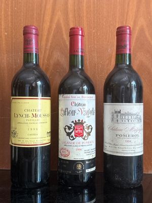 three bottles of wine are lined up on a black table