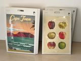 two bags of apples sitting on a table next to each other