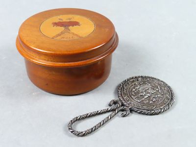 une petite boîte en bois sur laquelle se trouve un objet en métal