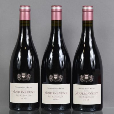 three bottles of wine are lined up on a table