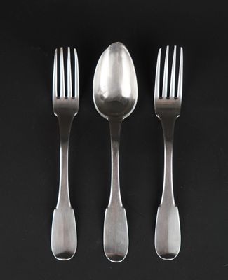 three forks and a spoon on a black surface