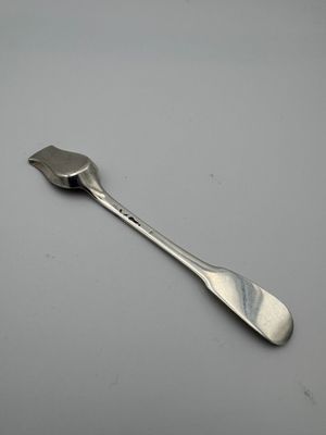 silver spoon on a gray surface with a white background