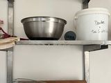 a metal shelf with pots and pans on it