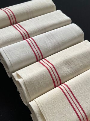 six serviettes rayées de blanc et de rouge empilées les unes sur les autres