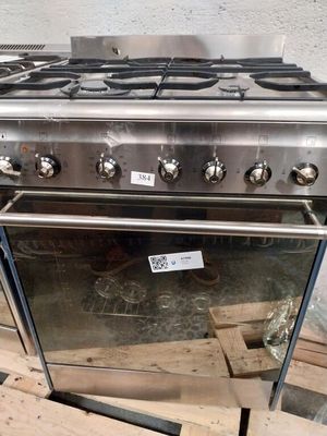 a stainless steel stove with four burners and a glass door