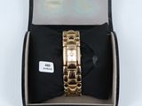 an image of a gold watch in a box with a bow tie