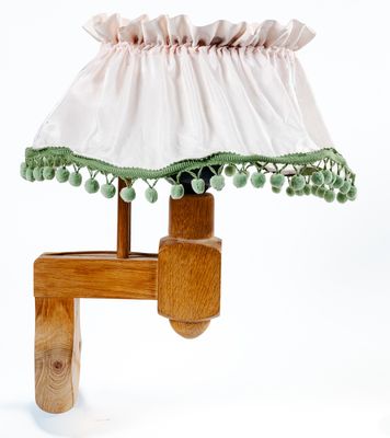 une lampe de table en bois surmontée d'un abat-jour blanc