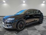 une voiture noire est garée dans une pièce au sol en damier