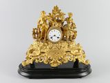 a gold clock on a black stand with a white background