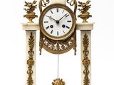 a white and gold clock on a stand on a white background