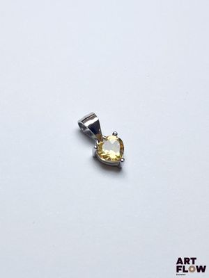 un pendentif en argent et en or orné d'une pierre jaune