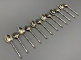 six cuillères en argent sont alignées sur une table