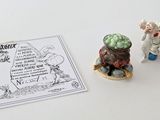 deux figurines posées sur une table à côté d'une feuille de papier