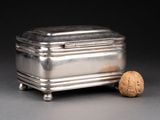 a silver box with a walnut in it on a table