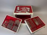 three silverware sets in a wooden box with a red lid