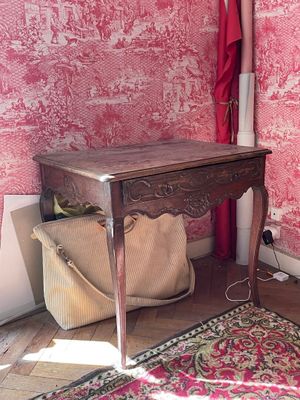 une petite table sur laquelle est posé un sac, dans une pièce