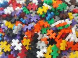 un tas de pièces de puzzle posées sur une surface blanche
