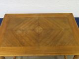 a wooden table with a square top on a blue tablecloth