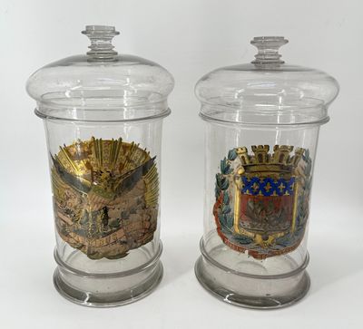 two clear glass jars with a coat of arms and a coat of arms on them