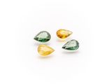 a group of three green and yellow gems on a white background