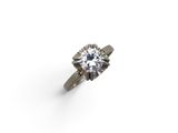 a close up of a diamond ring on a white surface