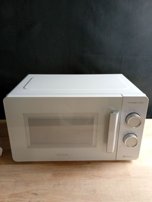 un micro-ondes posé sur une table en bois