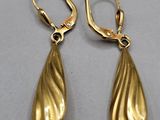 a pair of gold earrings on a white surface