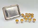 a silver plated tray with twelve cups and a silver tray with eight cups