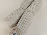 two white knitted mitts on a white surface with a price tag