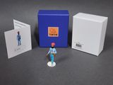 a small figurine of a man standing next to a blue box