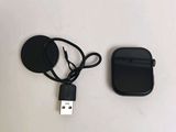 un téléphone portable noir et un chargeur posés sur une table blanche