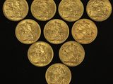 a close up of a bunch of gold coins on a black surface