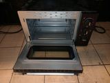 an open oven sitting on a tiled floor in a kitchen