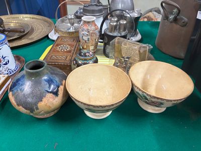 une table verte sur laquelle sont posés des bols et des assiettes, posée à son tour sur une table verte