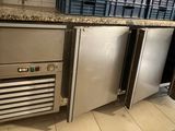 stainless steel refrigerators and freezers in a kitchen with marble counter tops