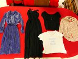 beaucoup de vêtements posés sur une table recouverte d'une nappe rouge