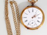 a gold pocket watch with a chain around it