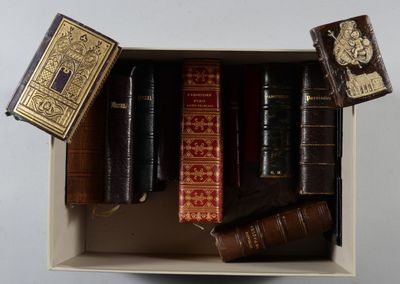 de nombreux livres dans une boîte posée sur une surface blanche