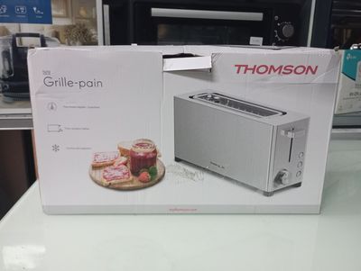 packaging of a toaster sitting on top of a counter next to a toaster