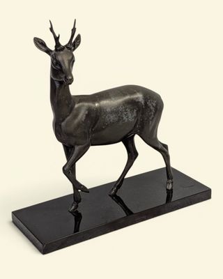 une image représentant une statue en bronze d'un cerf posée sur un socle noir