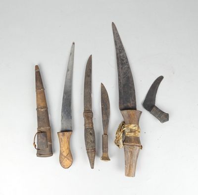 three old knives are sitting next to each other on a white surface