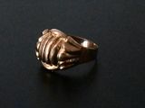 a gold ring that is sitting on a black surface