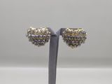 a pair of gold and silver earrings on a stand