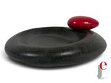a black stone with a red stone on top of it